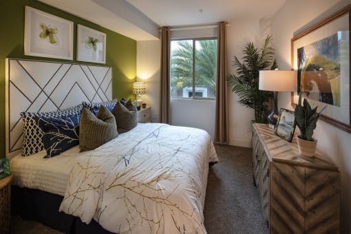 A bedroom with a large bed and a wooden nightstand at West Park Apartments, San Diego, CA, 92108