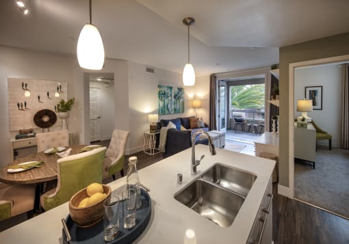 A modern kitchen with a white countertop and a large window at West Park Apartments, California, 92108