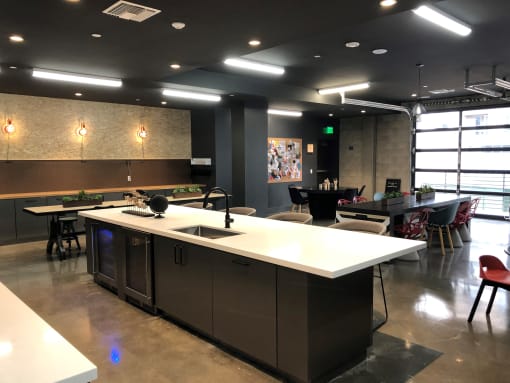 A modern kitchen with a white counter and black cabinets at Purl Apartments, San Diego, California