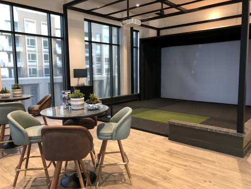 A conference room with a table, chairs, and a screen at Purl Apartments, California
