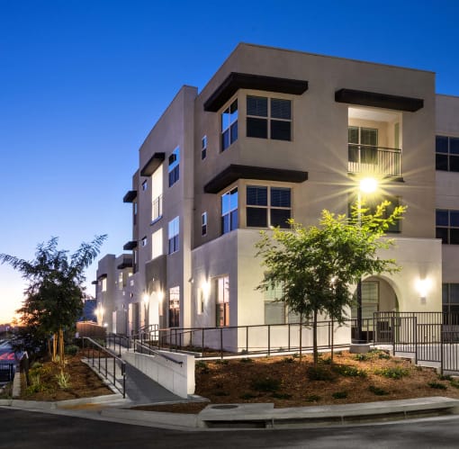 an image of a building at night with lights on it at Luma at El Corazon Apartments, Oceanside, CA 92056