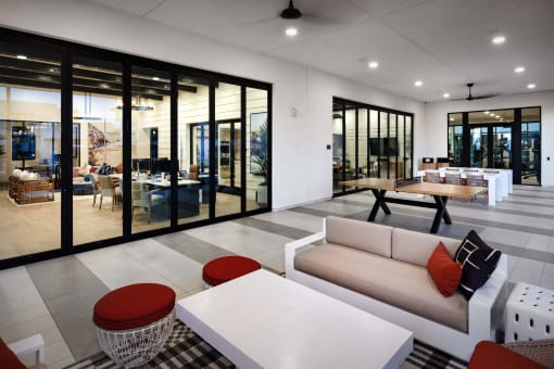 a living room with a white couch and tables at Luma at El Corazon Apartments, Oceanside, California