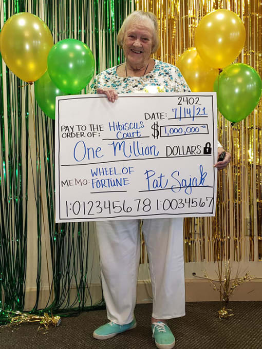 Senior Lady Is Taking A Photo With A Cheque at Hibiscus Court, Melbourne, FL, 32901
