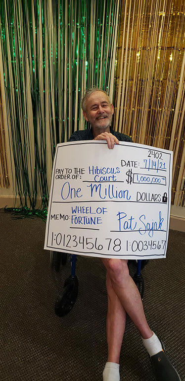 Senior Man Poses With A Cheque at Hibiscus Court, Melbourne
