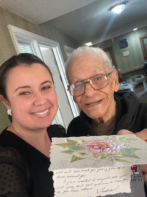 a woman and an older man holding a piece of paper
