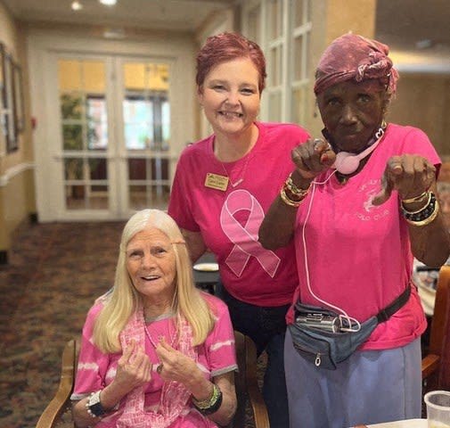 three women in pink shirts posing for a picture