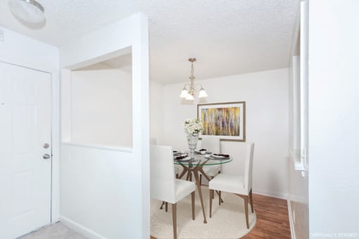 a bedroom with white walls and wood flooring and a closet