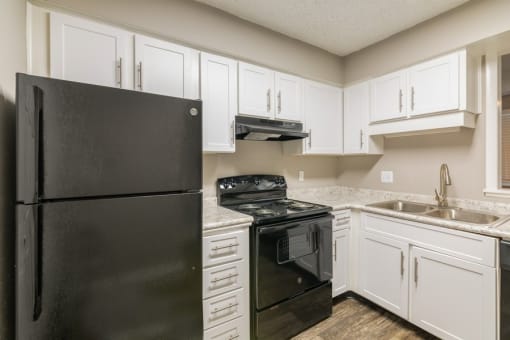 a kitchen with black appliances and white cabinets