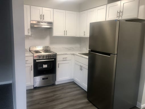 a kitchen with white cabinets and stainless steel appliances