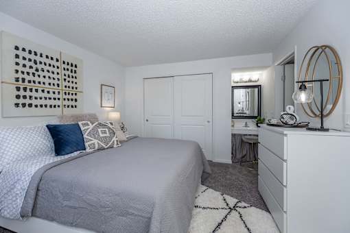 A bedroom with a large bed and a mirror on the wall.