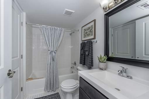 A bathroom with a white toilet, a white sink, and a shower curtain.