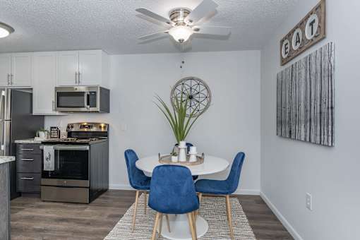 A kitchen with a dining table and chairs.
