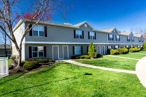 A row of houses with green lawns in front.