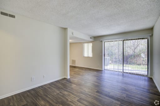 the spacious living room and dining room of an apartment