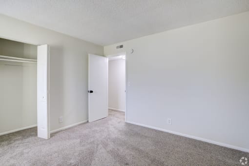 an empty living room with white walls and carpet