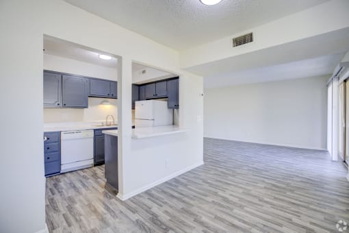 an open kitchen and living room with white and blue cabinets