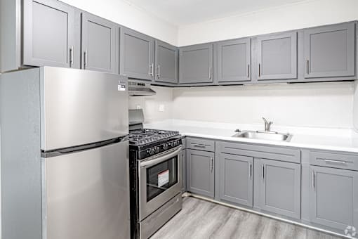 A kitchen with a stainless steel refrigerator and oven.