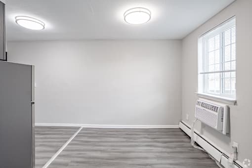 A room with a window and a radiator on the wall.