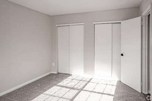 A room with two doors and a carpet on the floor.