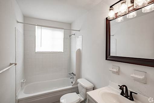 A white bathroom with a toilet, sink, and bathtub.