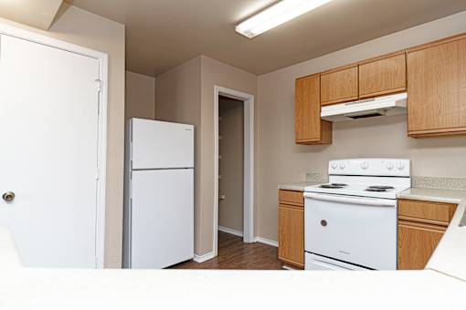 A small kitchen with a white fridge and stove.