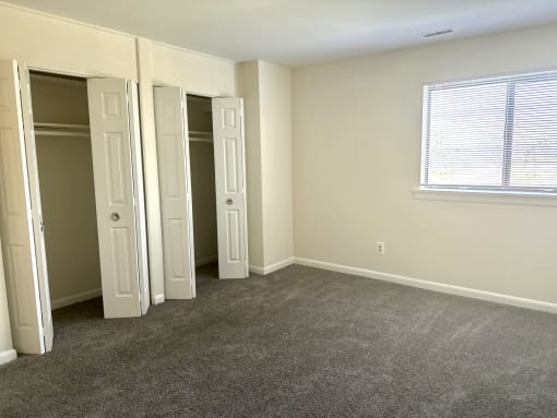 an empty room with three doors and a window