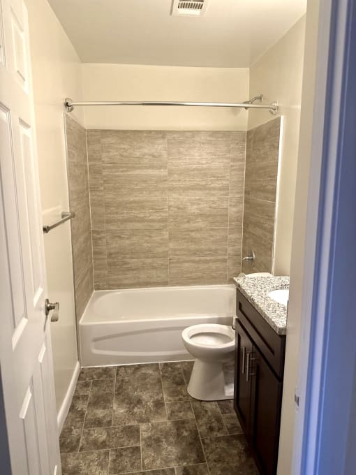 a small bathroom with a toilet and a bath tub