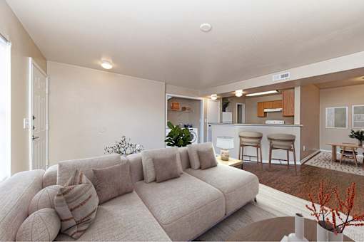 A living room with a large couch and a dining area in the background.