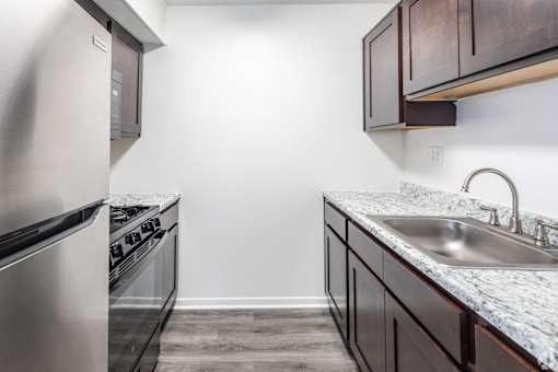 A kitchen with a stove top oven and a sink.