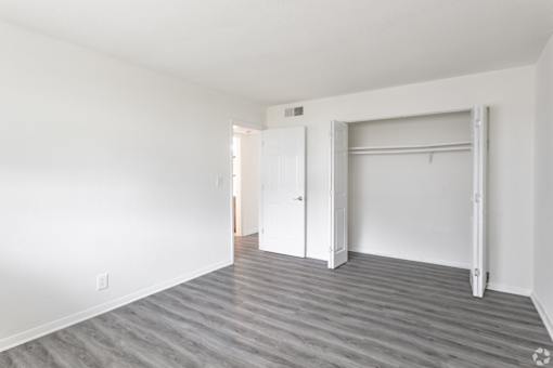A room with a white door and a grey floor.