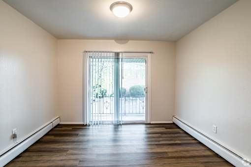 A room with a sliding glass door leading to a balcony.