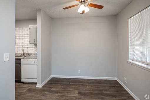 A room with a ceiling fan and a washing machine.