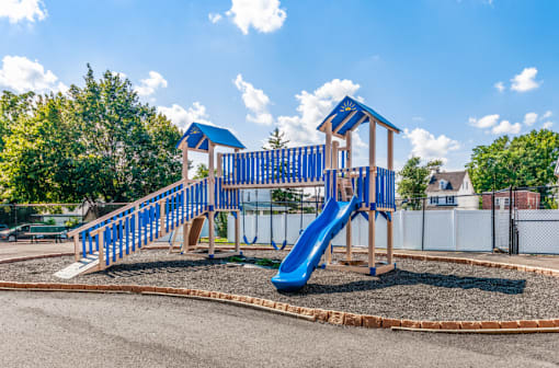A playground with a blue slide and wooden structure.