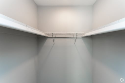 a empty room with two shelves and a white wall