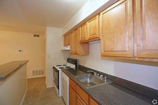 A kitchen with wooden cabinets and a stove top oven.