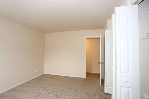 A room with a carpeted floor and white walls.