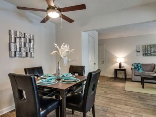 a dining room table with chairs and a ceiling fan