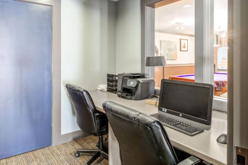 a desk with a laptop computer and a printer on it