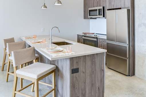 A kitchen with a white countertop and wooden cabinets.