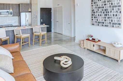 A modern kitchen with a black table in the middle.