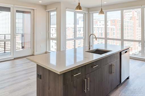 A modern kitchen with a large island and wooden cabinets.