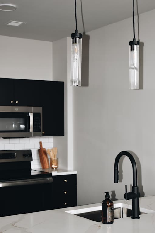 A modern kitchen with black cabinets and a white countertop.