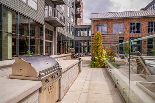 an outdoor patio with a grill and a building at The Audubon New Haven, New Haven, CT, 06511