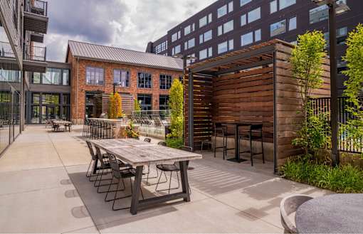 a patio with a table and chairs outside of a building at The Audubon New Haven, New Haven, CT, 06511
