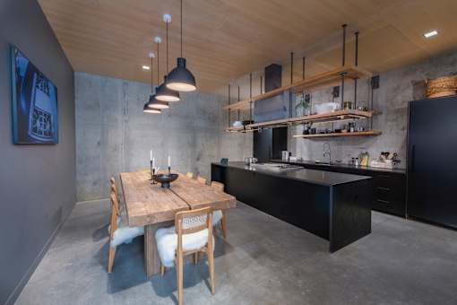 a kitchen with a wooden table and black cabinets at The Audubon New Haven, New Haven