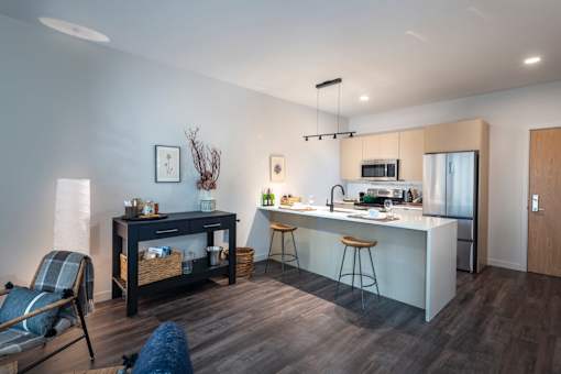 a kitchen and living room with an island and a refrigerator at The Audubon New Haven, New Haven, Connecticut