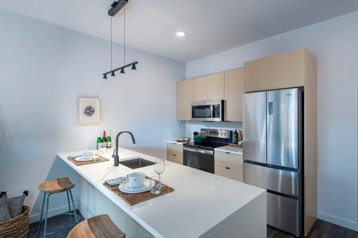 a kitchen with a large island and stainless steel refrigerator at The Audubon New Haven, Connecticut, 06511