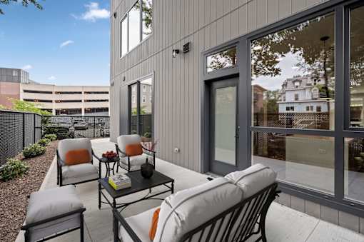 a patio with chairs and a table in front of a building at The Audubon New Haven, New Haven, 06511