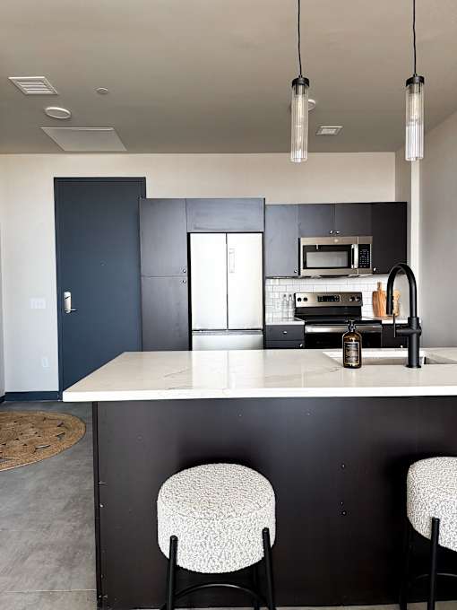 A kitchen with a white countertop and black cabinets.
