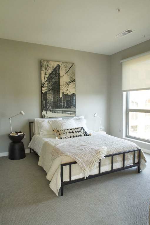 A bedroom with a large bed and a black and white picture on the wall.